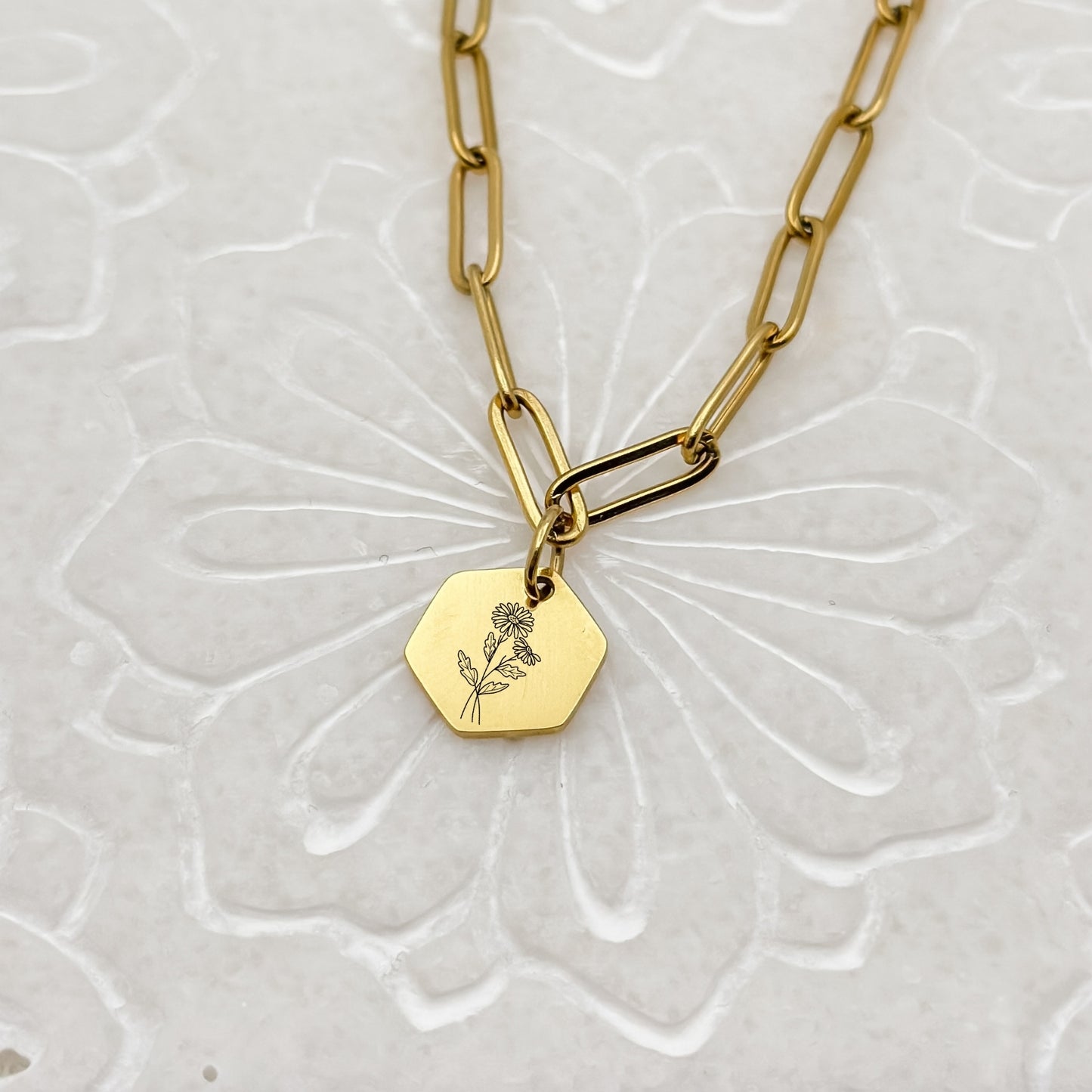 18K PVD Gold hexagon charm necklace with a delicate daisy engraving, symbolizing April birthdays. Hypoallergenic, waterproof, and tarnish-resistant.