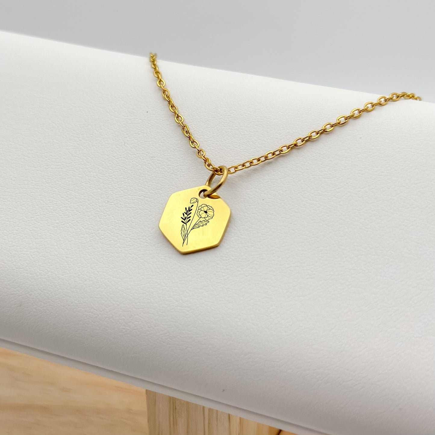 18K PVD Gold hexagon charm necklace featuring a hand-drawn poppy engraving, the birth flower for August. Hypoallergenic, waterproof, and tarnish-resistant.