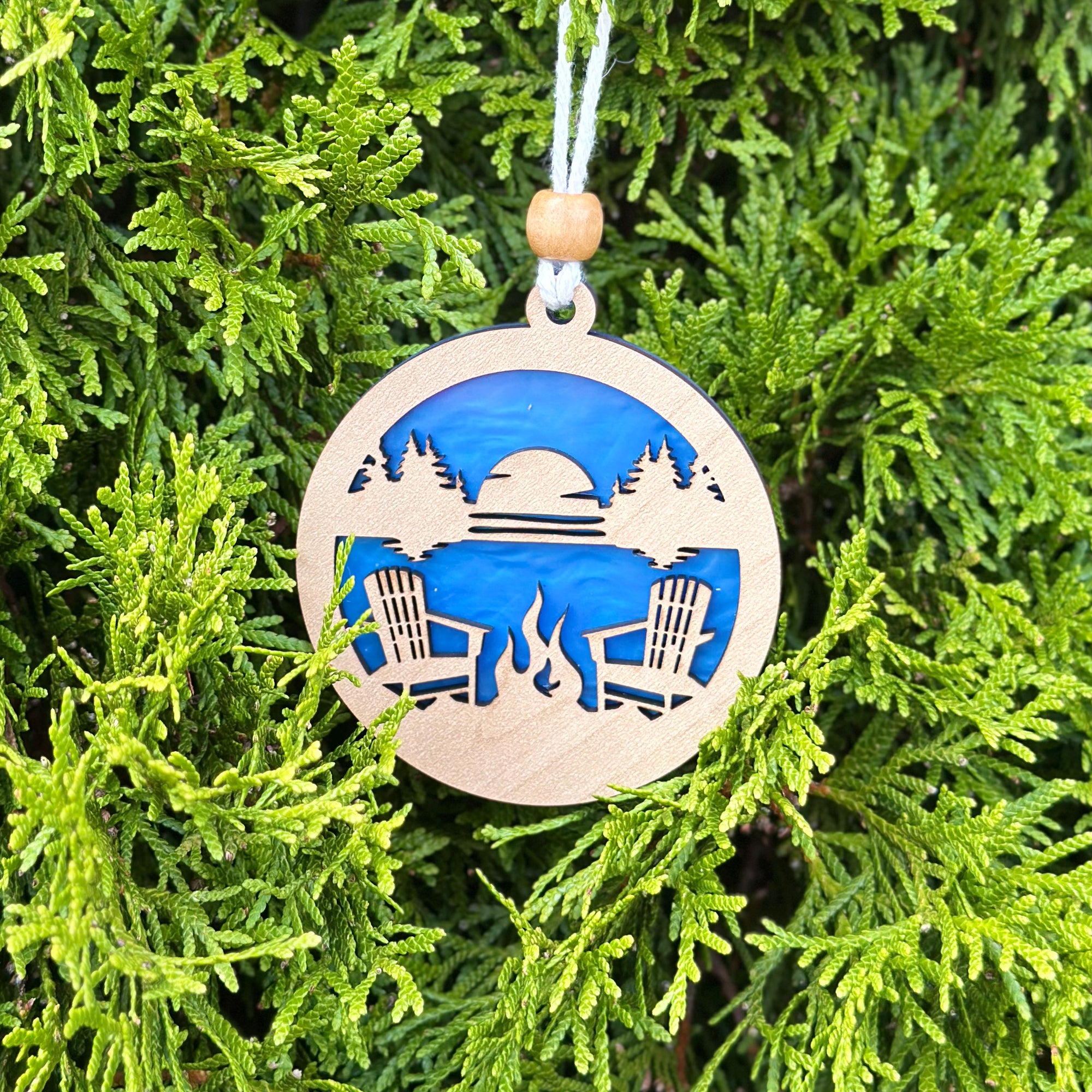 Decorative ornament with a camping scene on a green leaf background