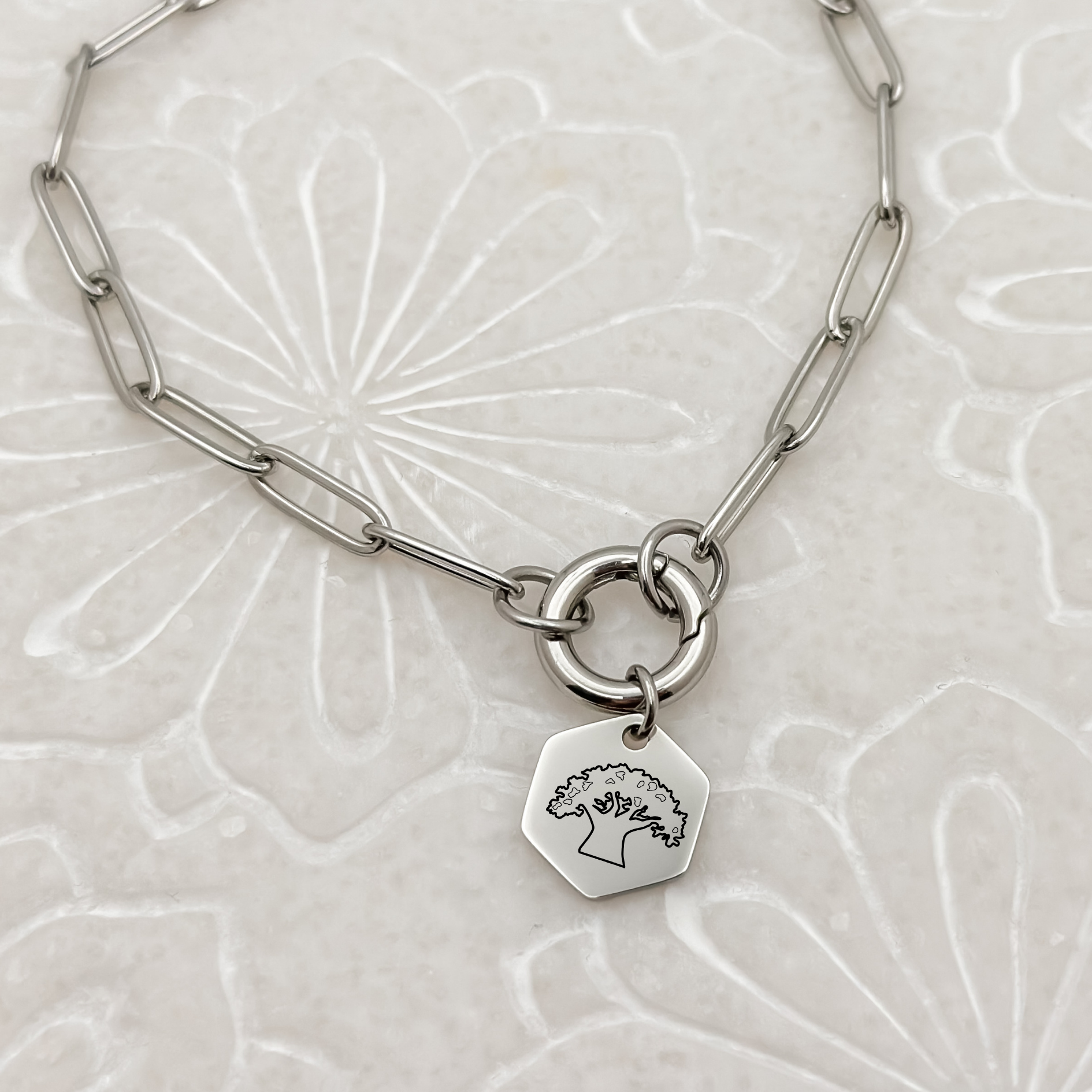 Animal K Charm Bracelet on a paperclip chain with charm keeper. Silver Hexagon Charm featuring an engraved Tree of Life. Hypoallergenic, waterproof, stainless steel jewelry. 