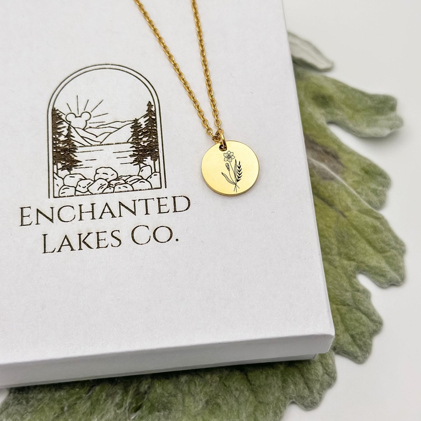 Elegant 18K PVD Gold circle charm necklace featuring a detailed daffodil engraving, symbolizing March birthdays. Hypoallergenic, waterproof, and tarnish-resistant.