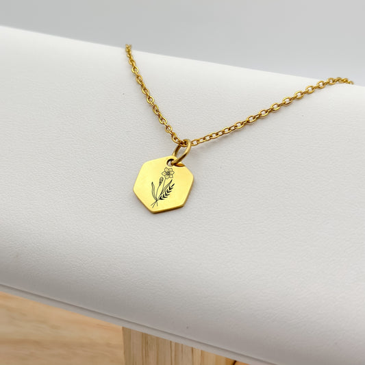 18K PVD Gold hexagon charm necklace featuring a hand-drawn daffodil engraving, the birthflower for March. Hypoallergenic, waterproof, and tarnish-resistant.
