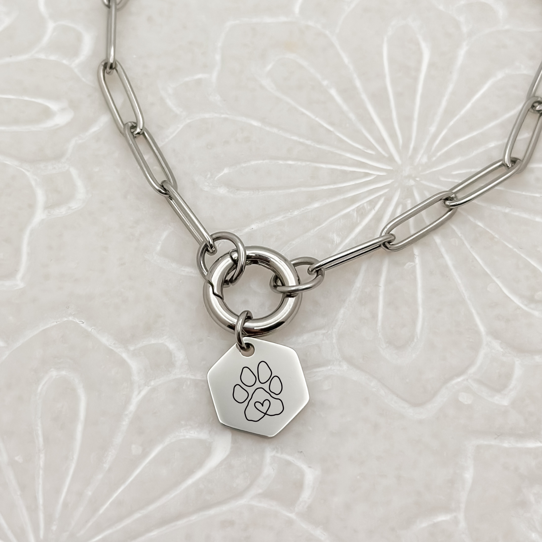 Silver hexagon puppy paw charm on a charm keeper paperclip chain necklace, featuring a minimalist paw print design. Perfect for women’s jewelry collections and pet lovers, crafted from hypoallergenic, waterproof, and tarnish-resistant stainless steel.