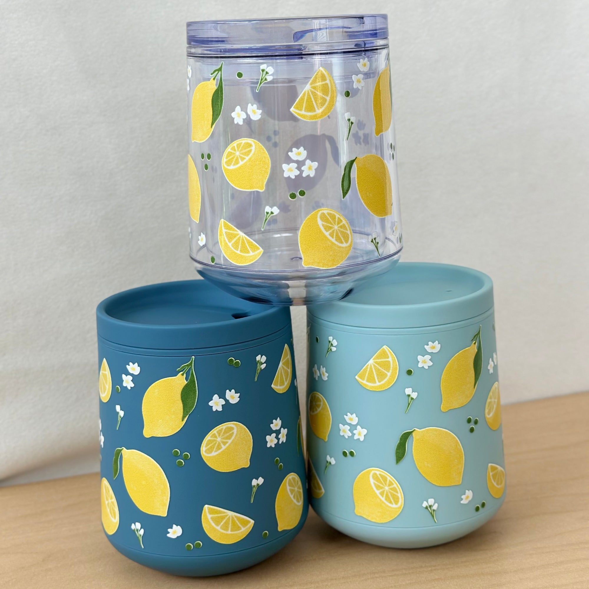 Three tumblers with lemon pattern on a wooden surface