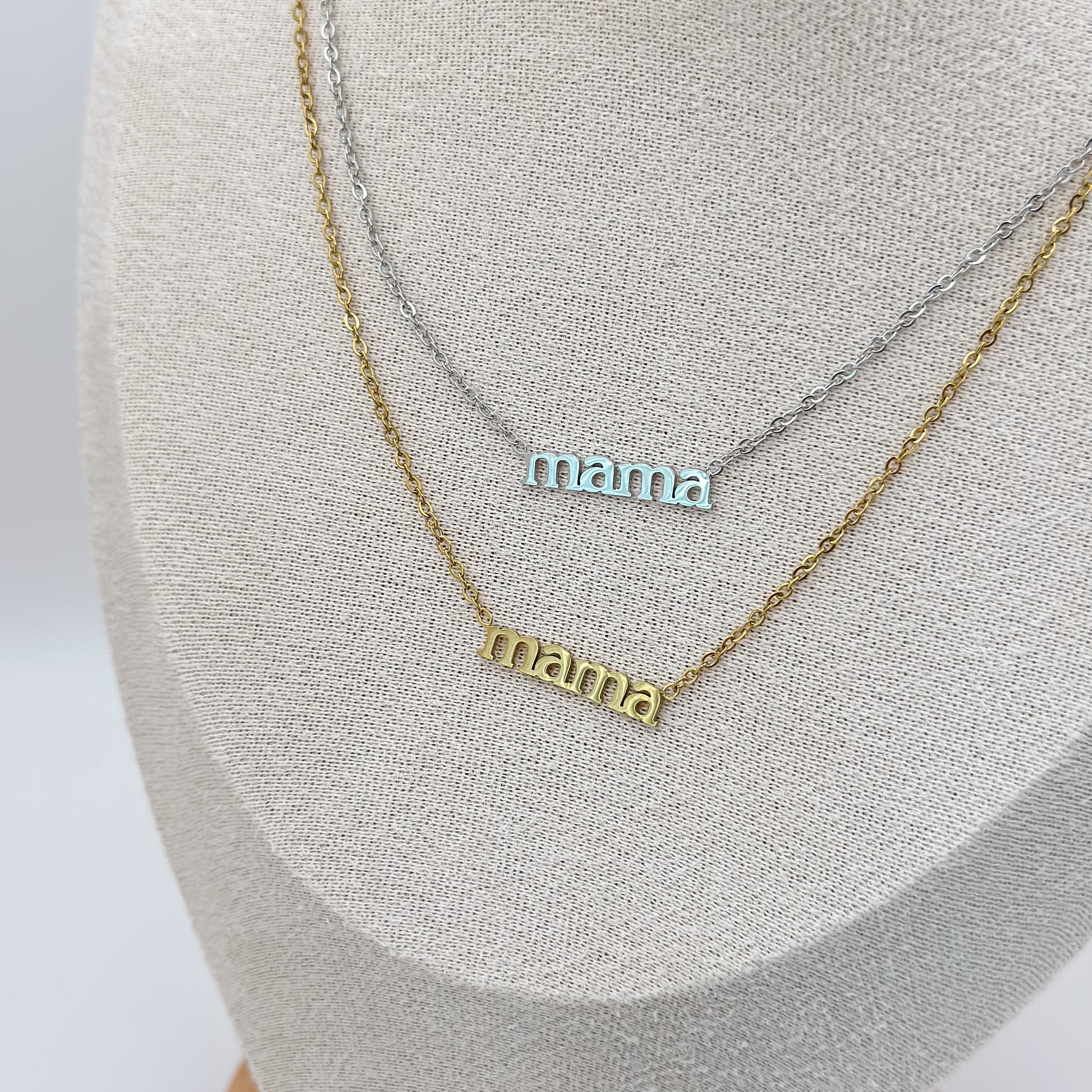 Two 'mama' necklaces on a gray surface