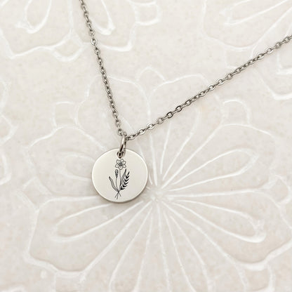 Minimalist silver circle charm necklace with a beautifully engraved daffodil, the March birthflower. Hypoallergenic, waterproof, and tarnish-resistant.