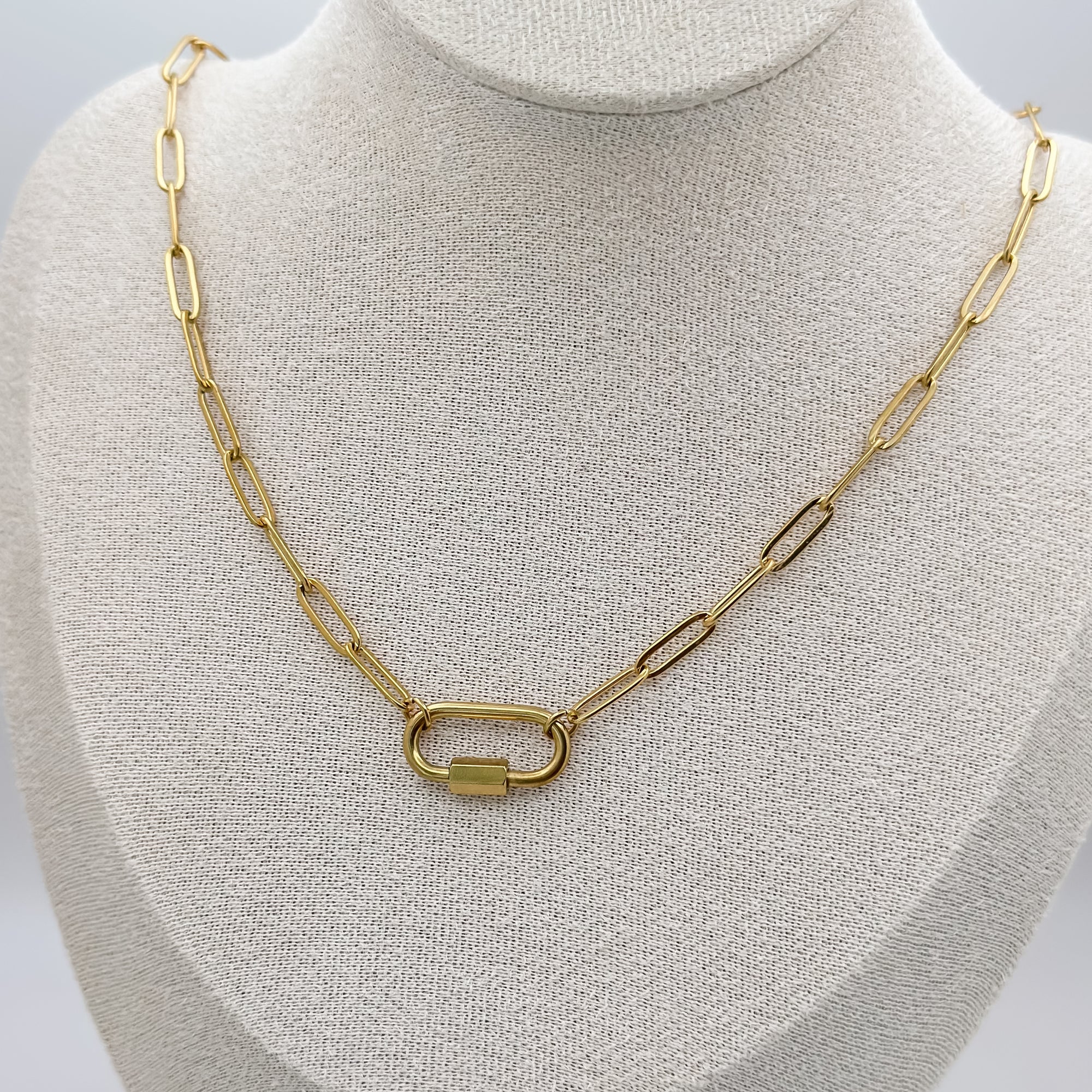 Gold chain necklace on a mannequin bust against a neutral background